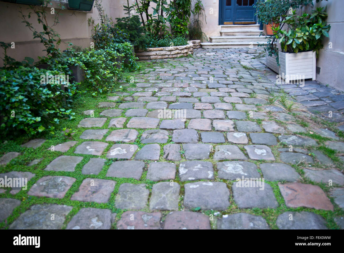 Photograph of a cobblestone courtyard garden in Paris Stock Photo Alamy