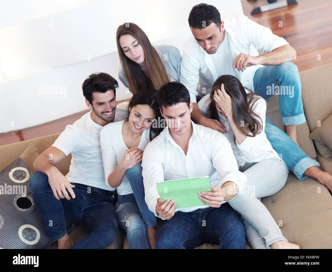 group of friends taking selfie photo with tablet at modern home indoors ...