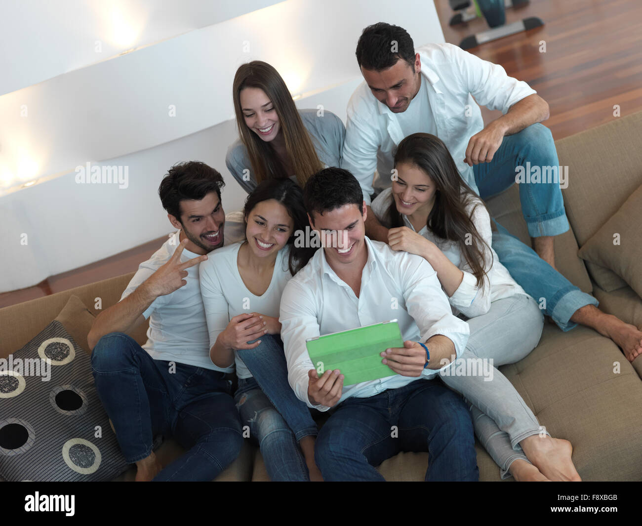 group of friends taking selfie photo with tablet at modern home indoors ...