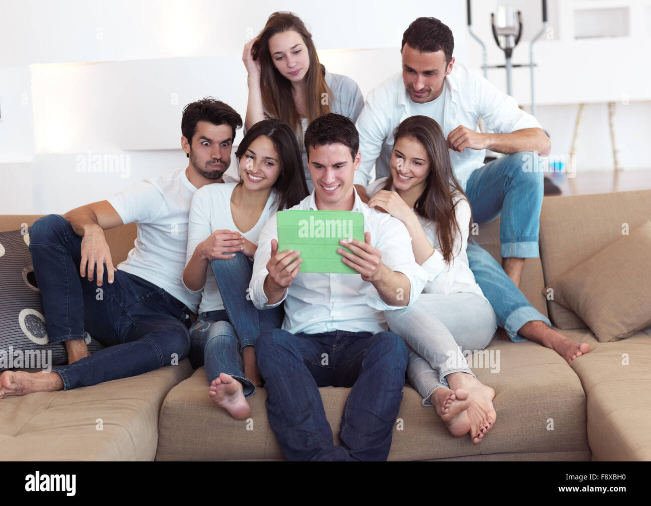 group of friends taking selfie photo with tablet at modern home indoors ...