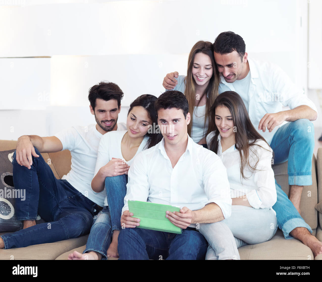 group of friends taking selfie photo with tablet at modern home indoors ...