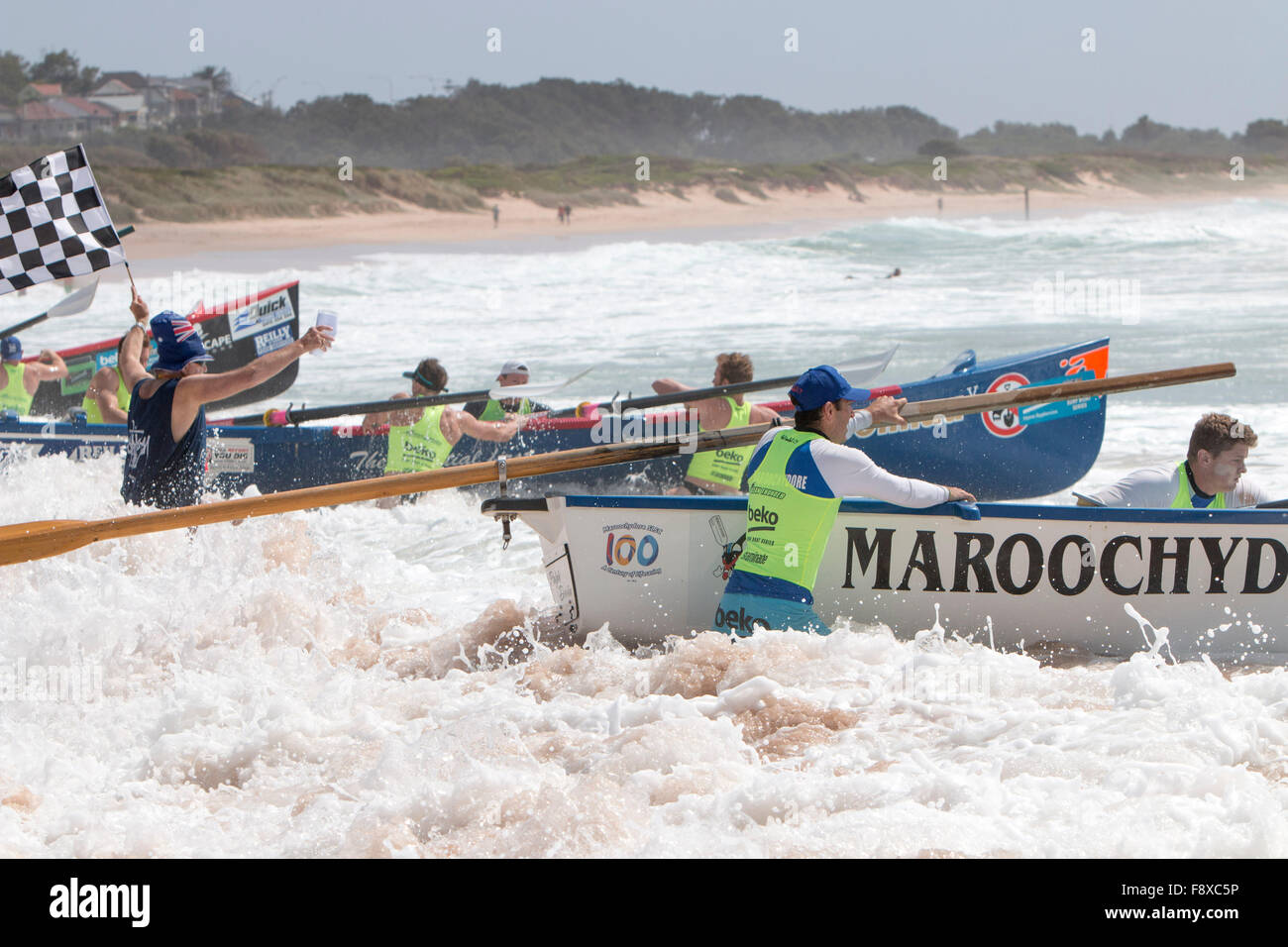 Sydney, Australia. 12th December, 2015. Ocean Thunder Professional surfboat racing carnival from Dee Why Beach involves 24 elite mens teams and 12 elite womens teams from around Race Marshall with chequered flag prepares to start one of the surfboat races Credit:  model10/Alamy Live News Stock Photo