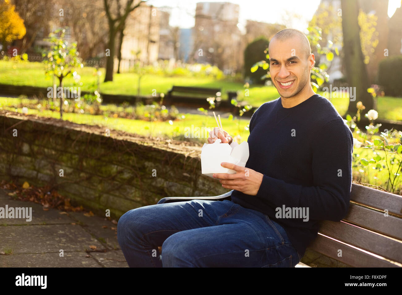 young man enjoying a take-away in the park Stock Photo