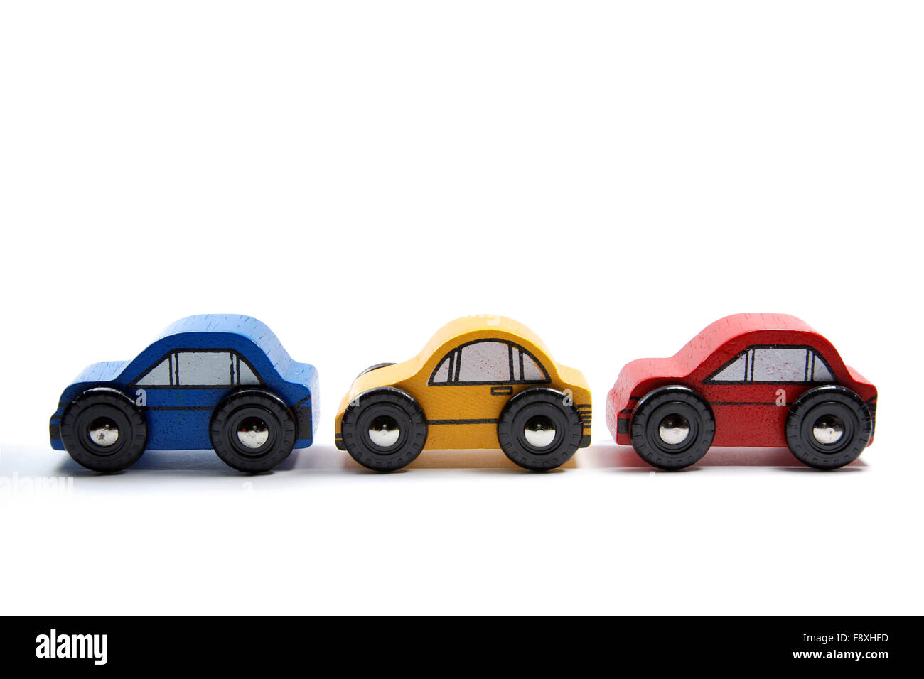 Three wooden toy cars in a row Stock Photo