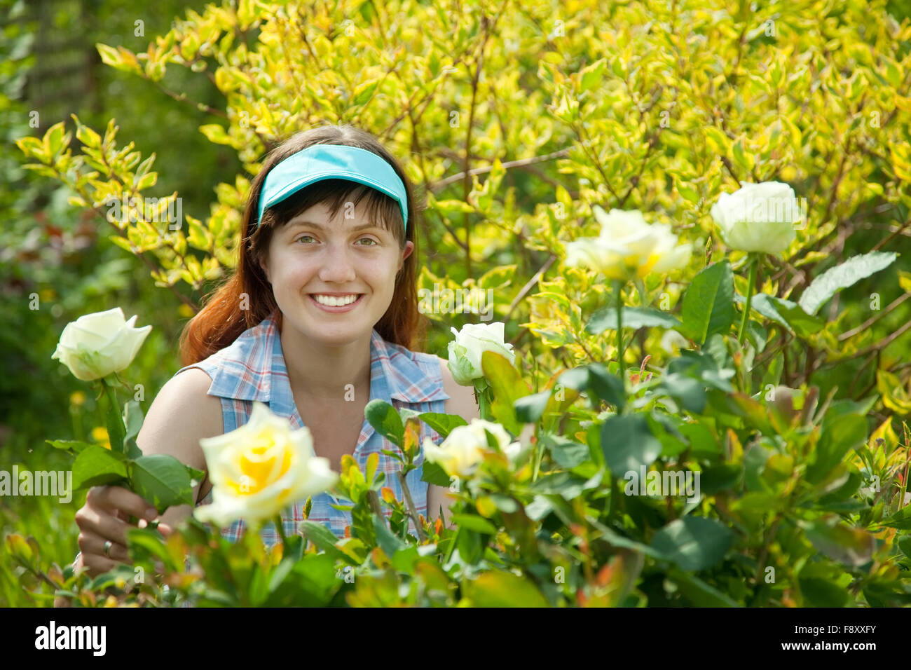 young woman in rose plant at garden Stock Photo - Alamy