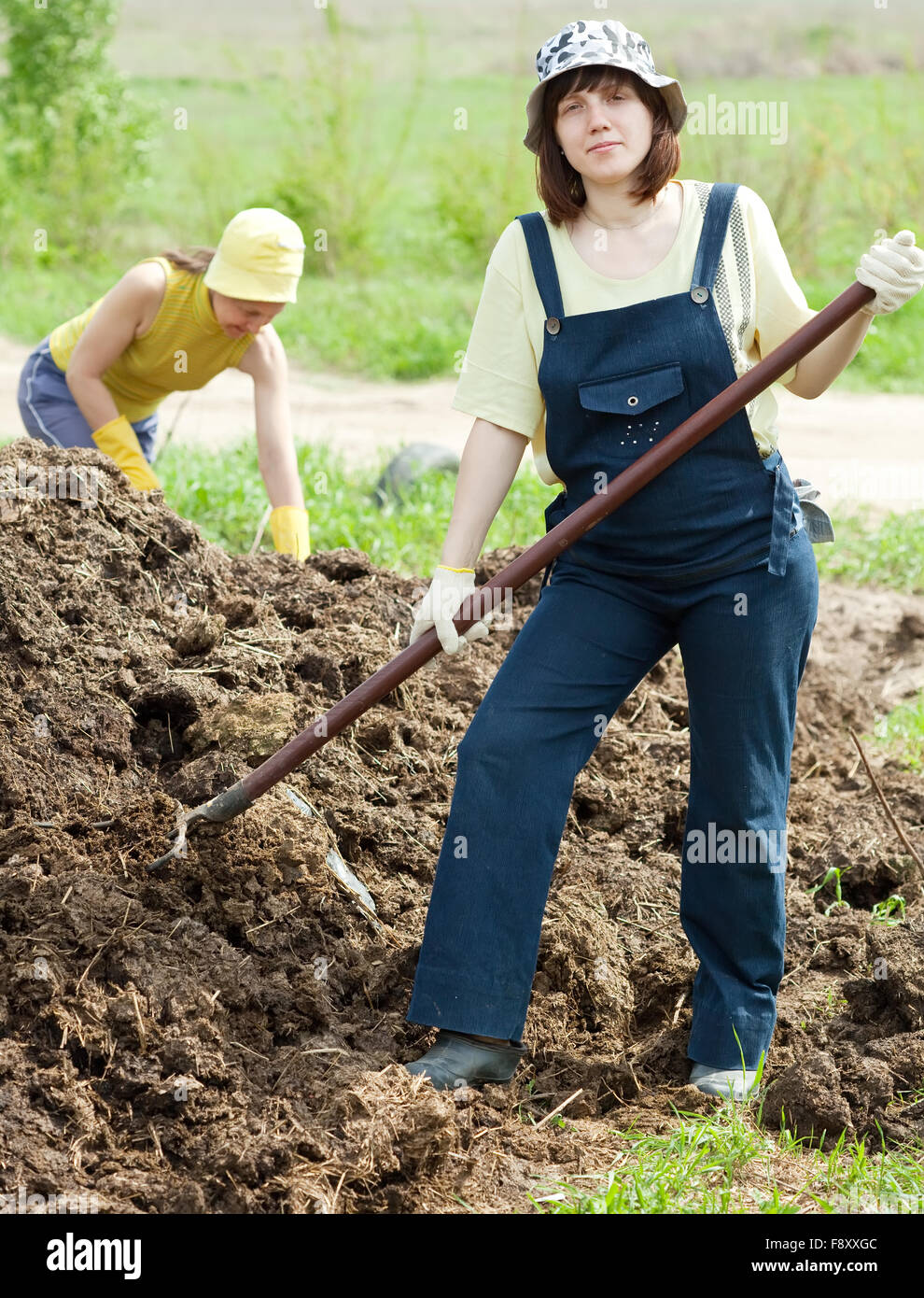 women throws the manure pitchfork in the field Stock Photo Alamy