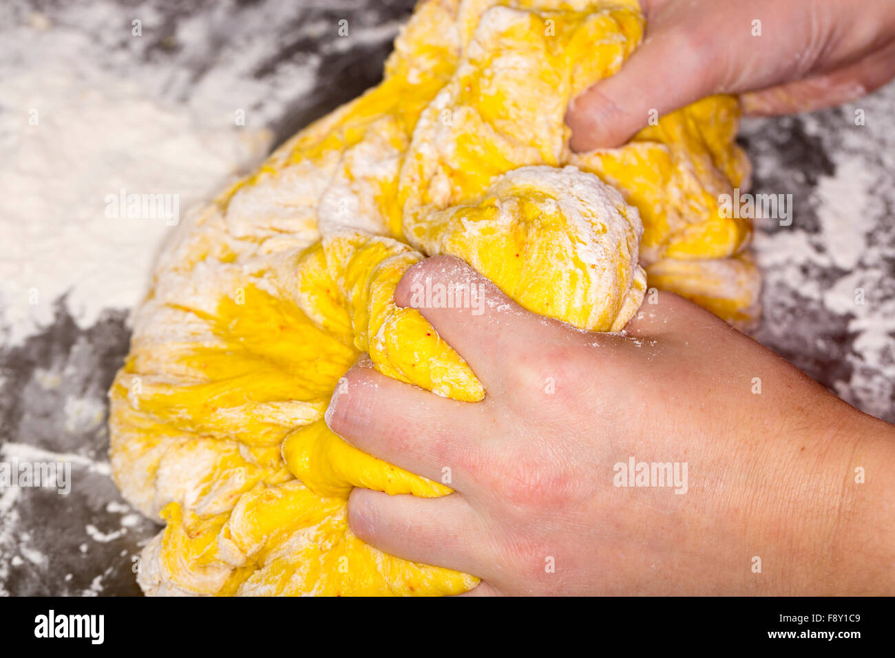 Hands in Saffron Bun Dough Stock Photo