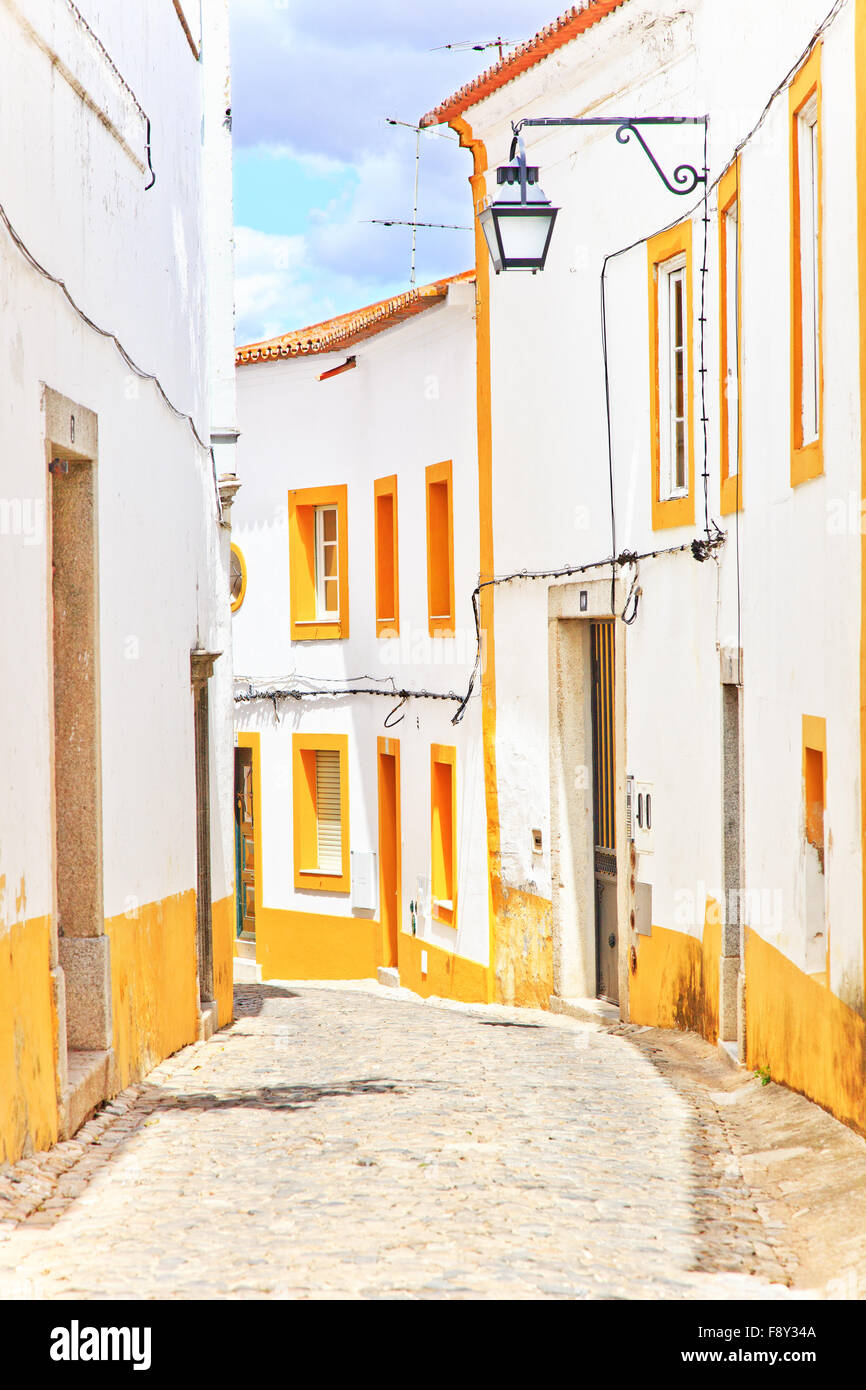 Old urban street in Evora town. White facades and colorful windows. Alentejo, Portugal, Europe. Stock Photo
