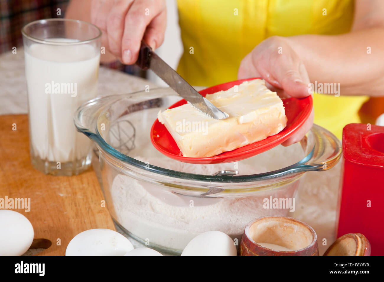 Closeup of cook hands adds margarine into dough Stock Photo