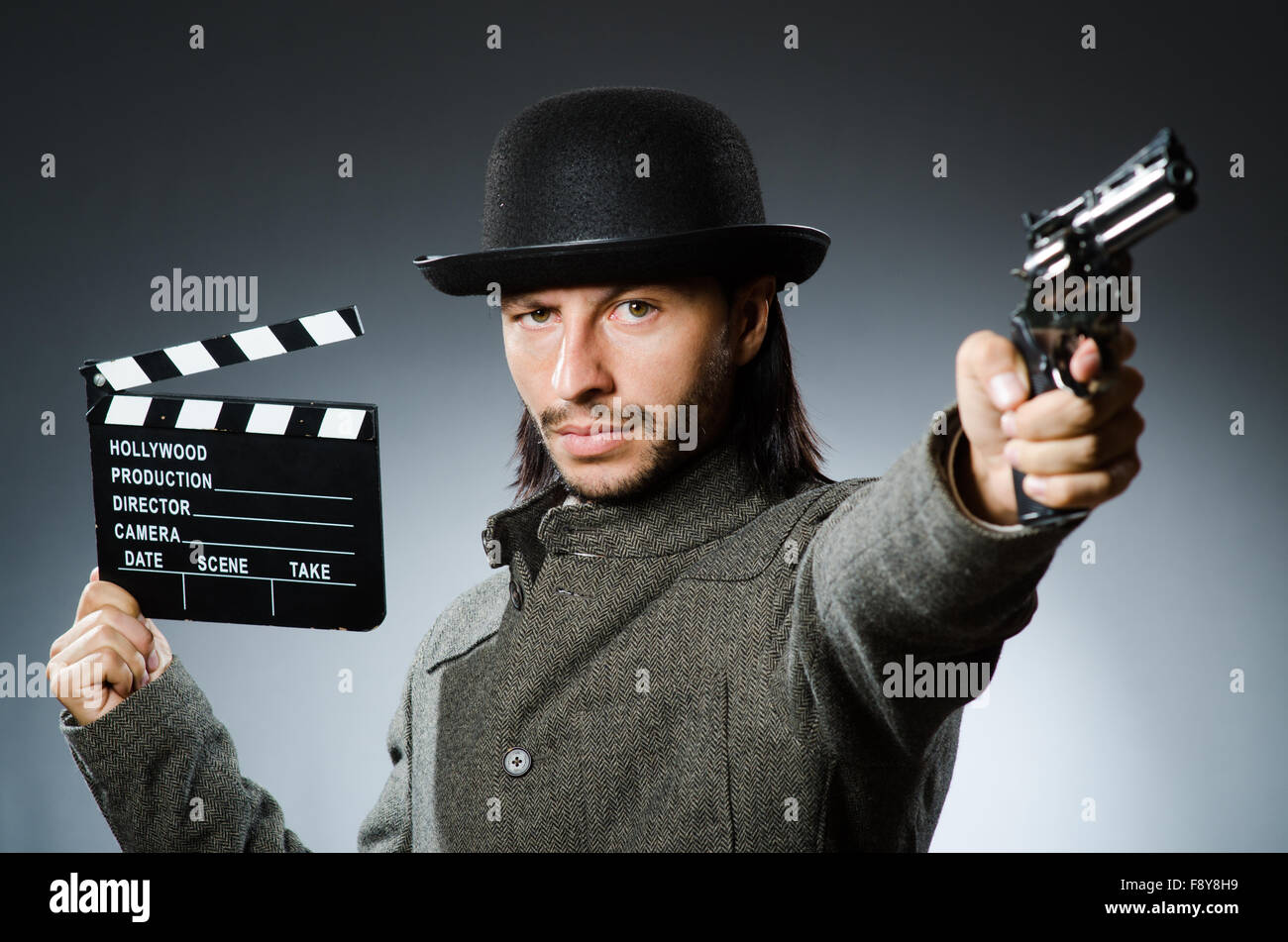 Man with gun and movie clapboard Stock Photo - Alamy