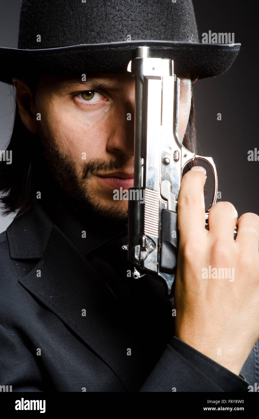 Man wearing vintage hat with gun Stock Photo Alamy