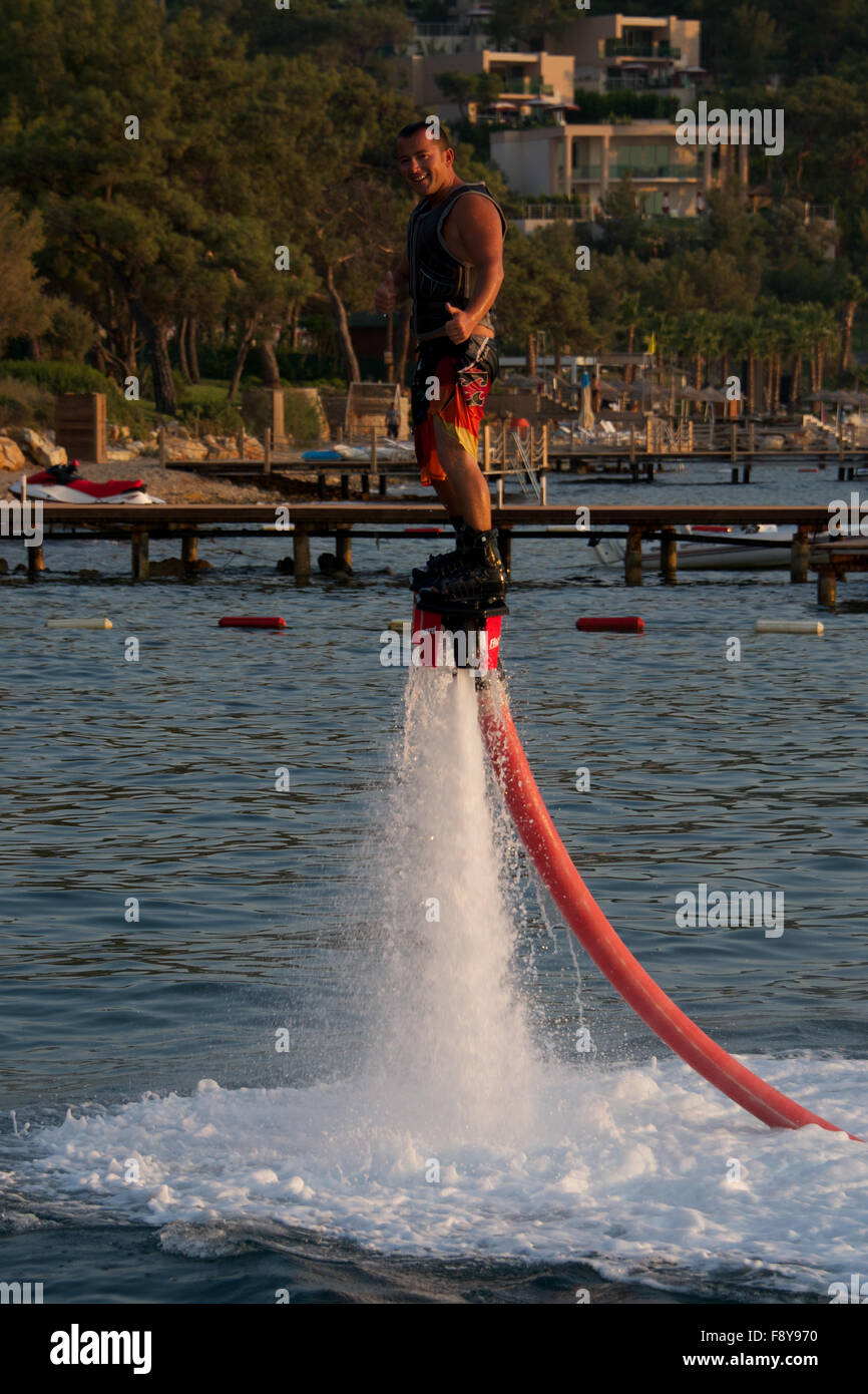 Flyboarder giving thumbs-up sign in golden light Stock Photo - Alamy