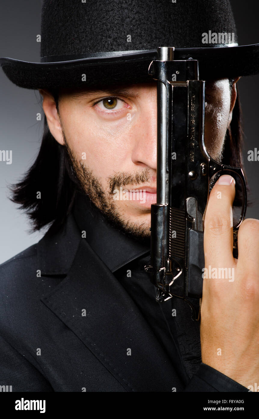 Man wearing vintage hat with gun Stock Photo Alamy