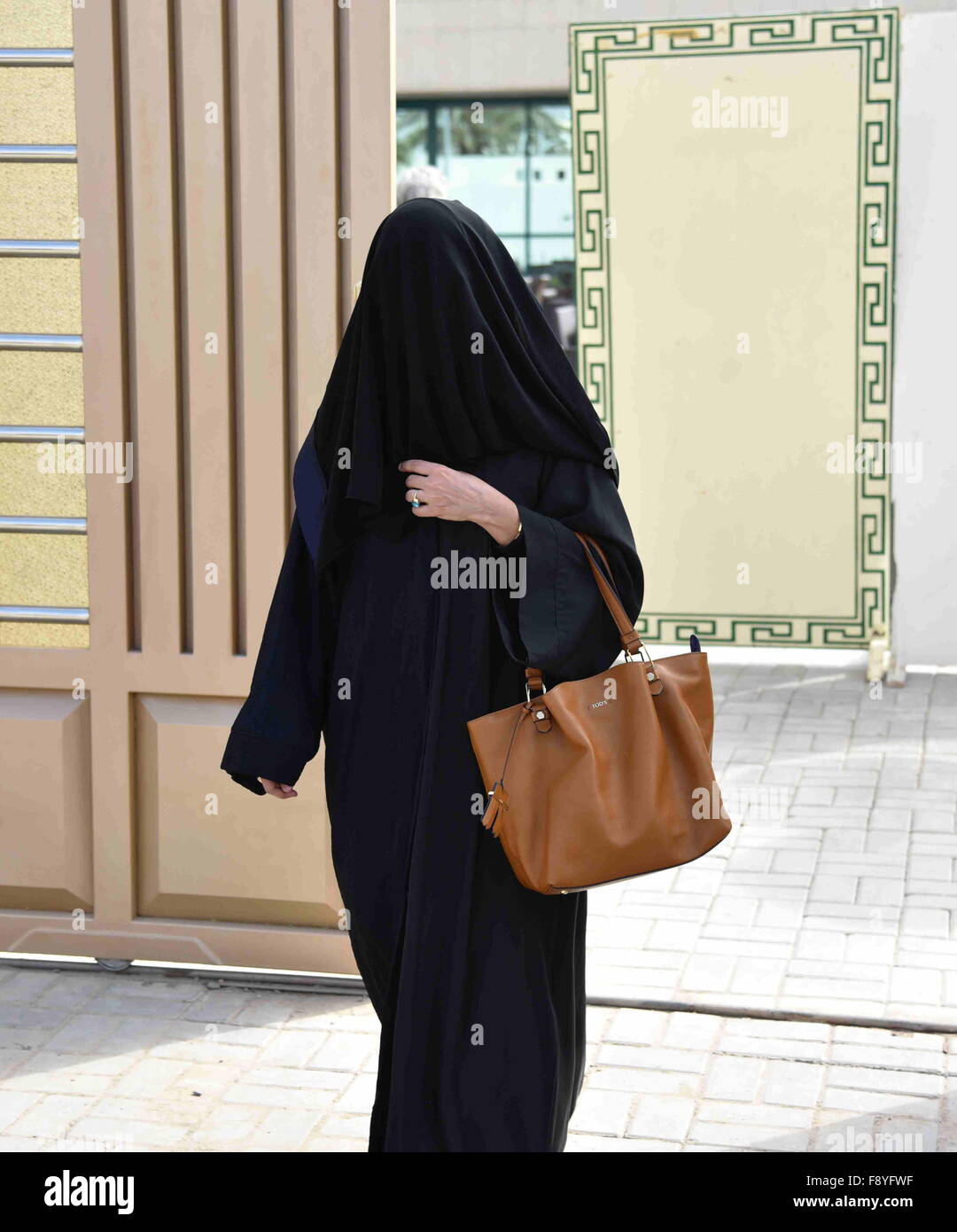 Riyadh, Saudi Arabia. 12th December, 2015. A woman walks out of a polling station after casting her vote for municipal elections in Riyadh, Saudi Arabia, Dec. 12, 2015. More than 1.4 million people are eligible to vote, including 130,637 females who will be allowed to contest and cast ballots in the third municipal poll. It is Saudi Arabia's first elections open to women. (Xinhua/Wang Bo)(azp) Credit:  Xinhua/Alamy Live News Stock Photo