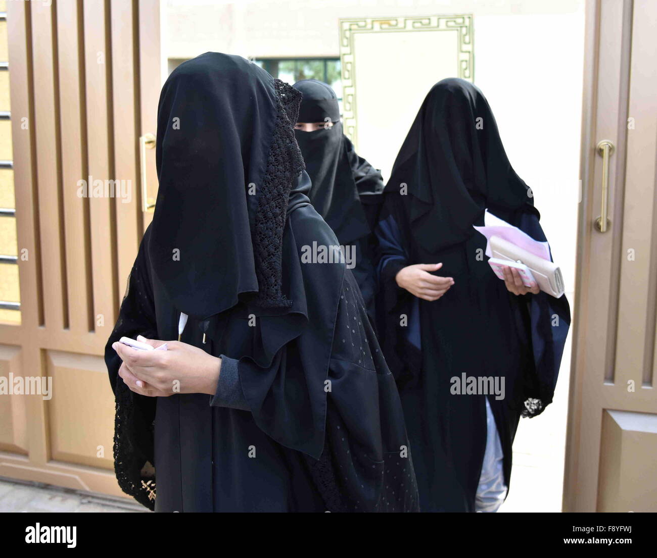 Riyadh, Saudi Arabia. 12th December, 2015. Women walk out of a polling station after casting their votes for municipal elections in Riyadh, Saudi Arabia, Dec. 12, 2015. More than 1.4 million people are eligible to vote, including 130,637 females who will be allowed to contest and cast ballots in the third municipal poll. It is Saudi Arabia's first elections open to women. (Xinhua/Wang Bo)(azp) Credit:  Xinhua/Alamy Live News Stock Photo