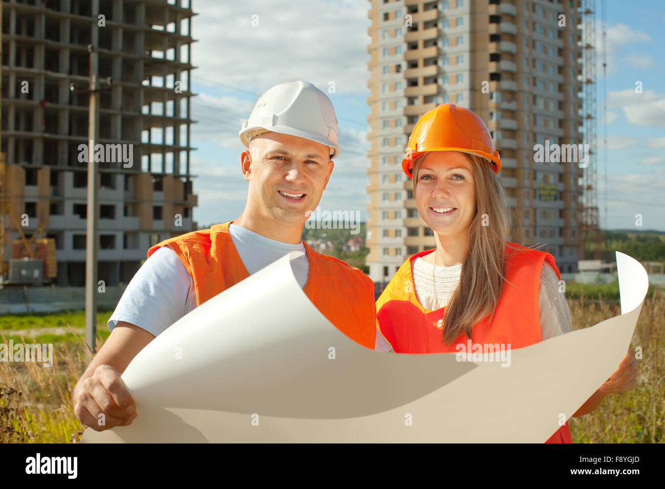 two happy builders in hardhat works on the building site Stock Photo ...