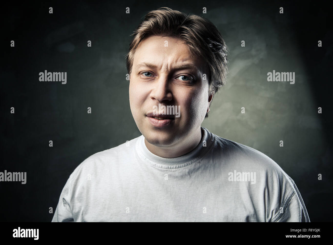 emotional middle aged doubting man over gray Stock Photo