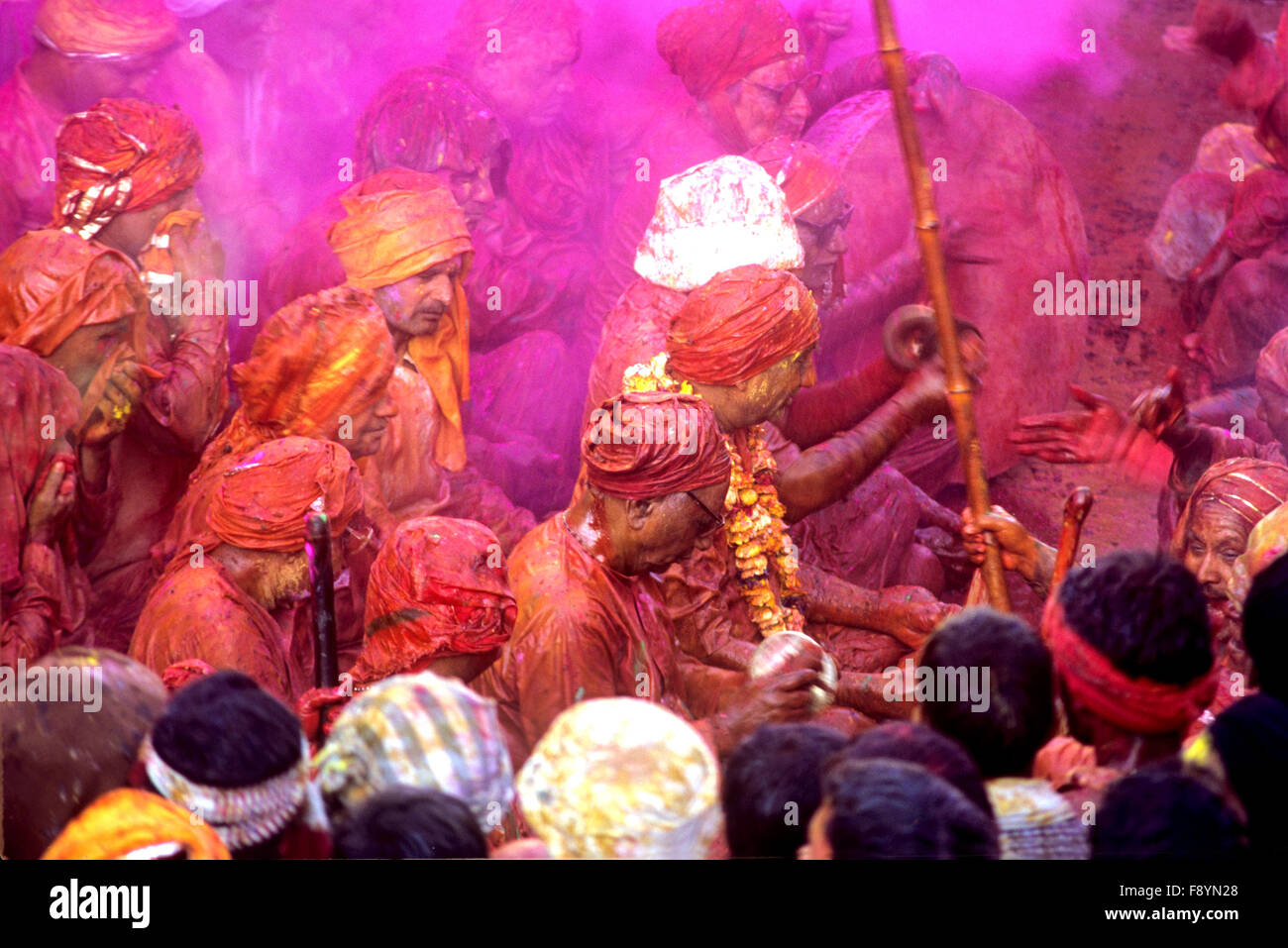 People daubed in colored water, singing a hymn moving towards a temple during “Holi Festival” at, Mathura, Uttar Pradesh, India. Stock Photo