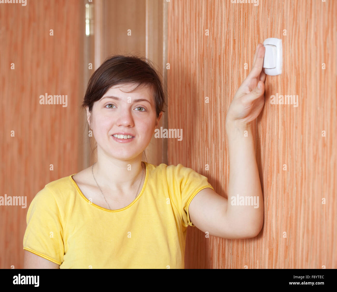 Young woman turning off the light switch in home Stock Photo Alamy