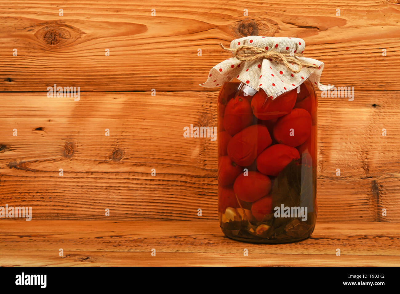 One Big Glass Jar Of Homemade Pickled Tomatoes With Dotted Textile
