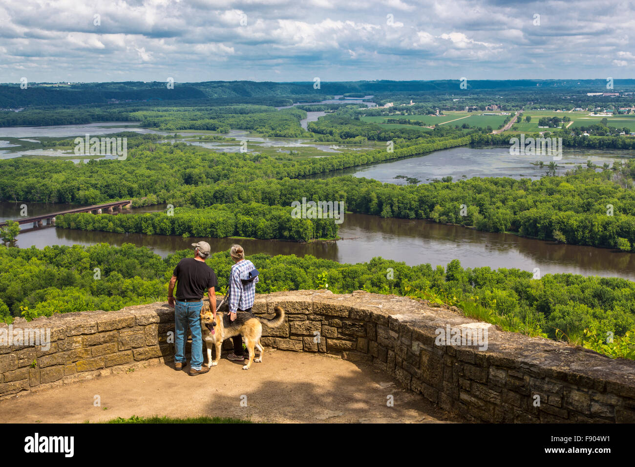 Couple with dog at scenic overlook of confluence of Wisconsin & Mississippi Rivers from Wyalusing State Park in Wisconsin Stock Photo