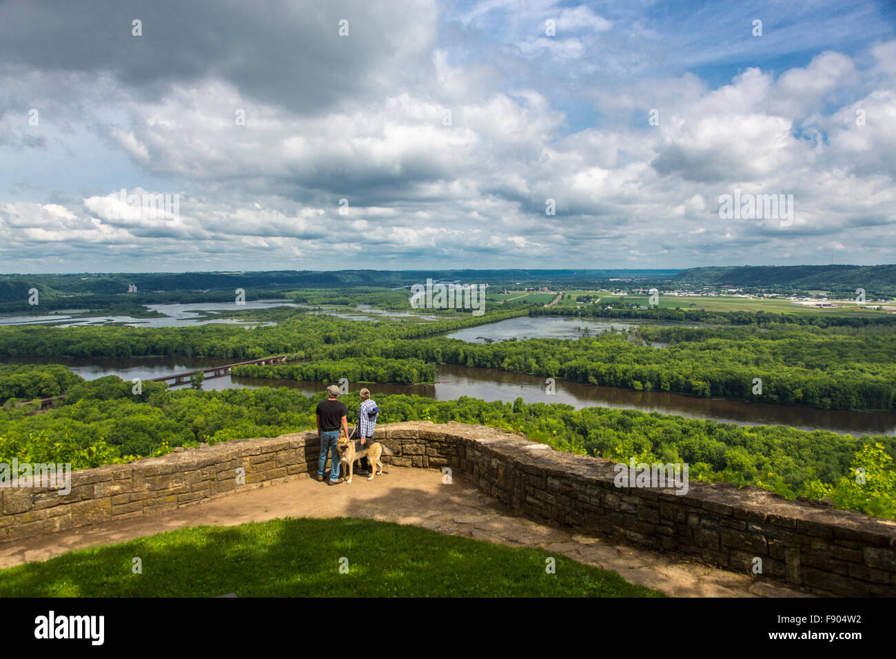 Couple with dog at scenic overlook of confluence of Wisconsin & Mississippi Rivers from Wyalusing State Park in Wisconsin Stock Photo