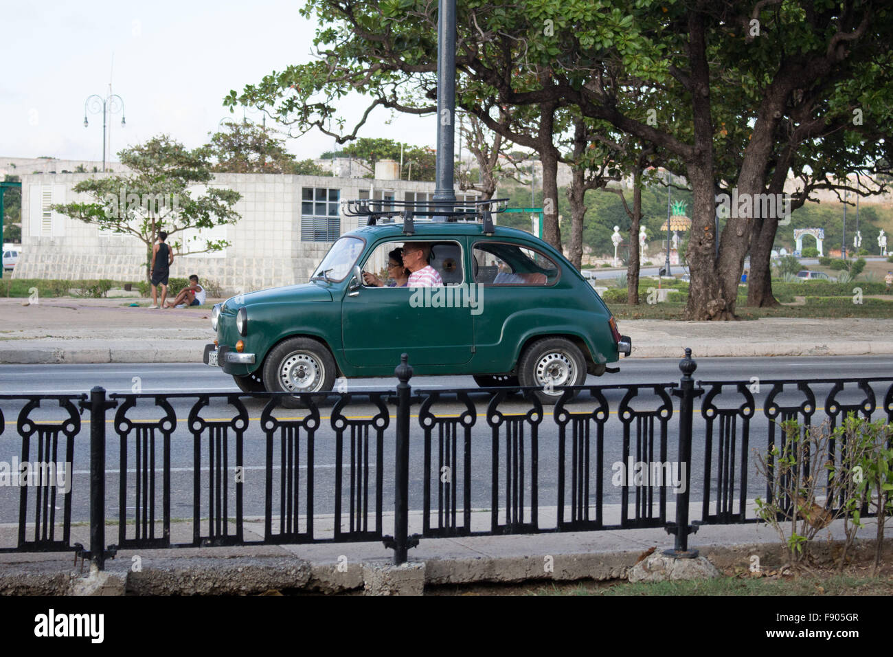 People are driving an old green car in Cuba. They are in Habana Stock Photo