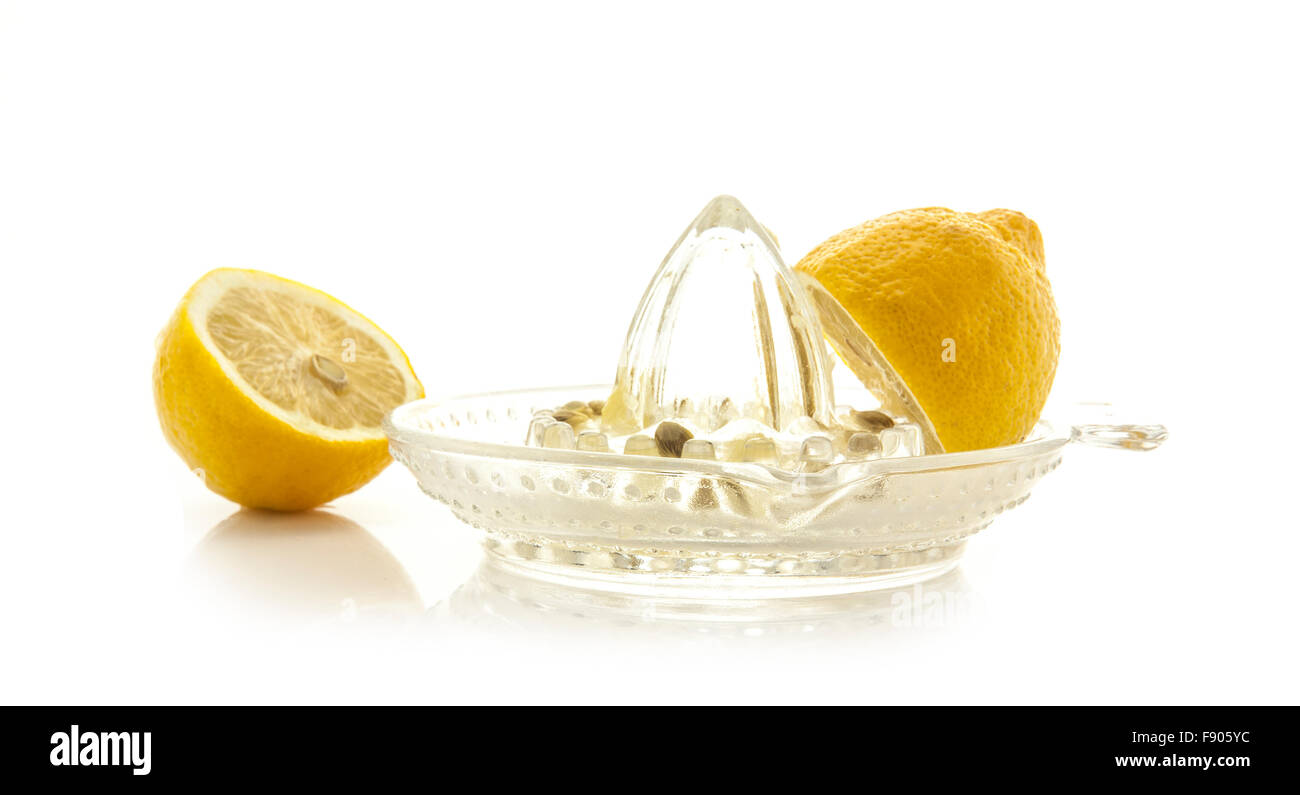 Glass citrus squeezer with lemons and juice on a white background Stock