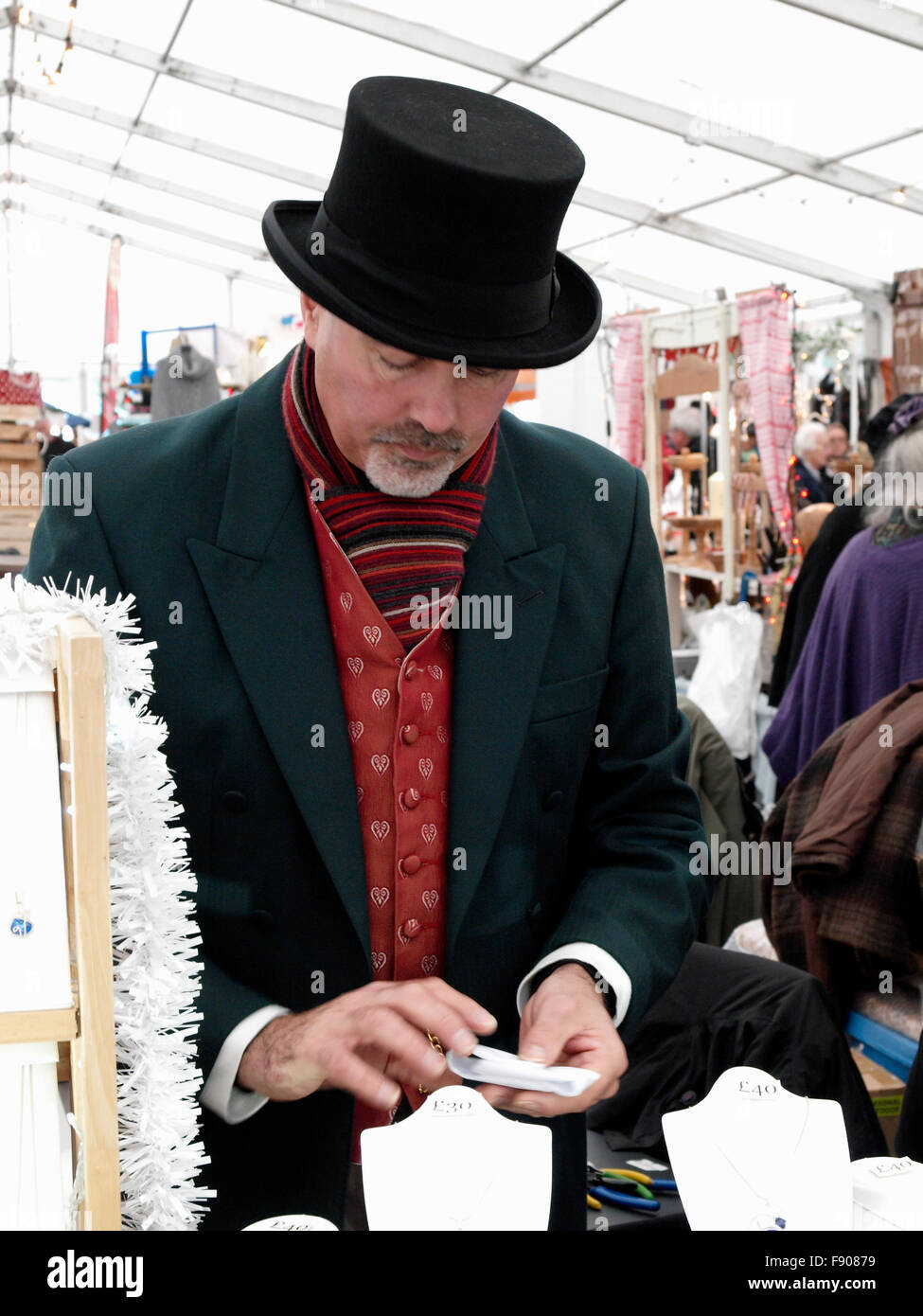 Jewelery seller at the Truro Christmas Market where all the stall holders wear Victorian dress, Truro, Cornwall, UK Stock Photo