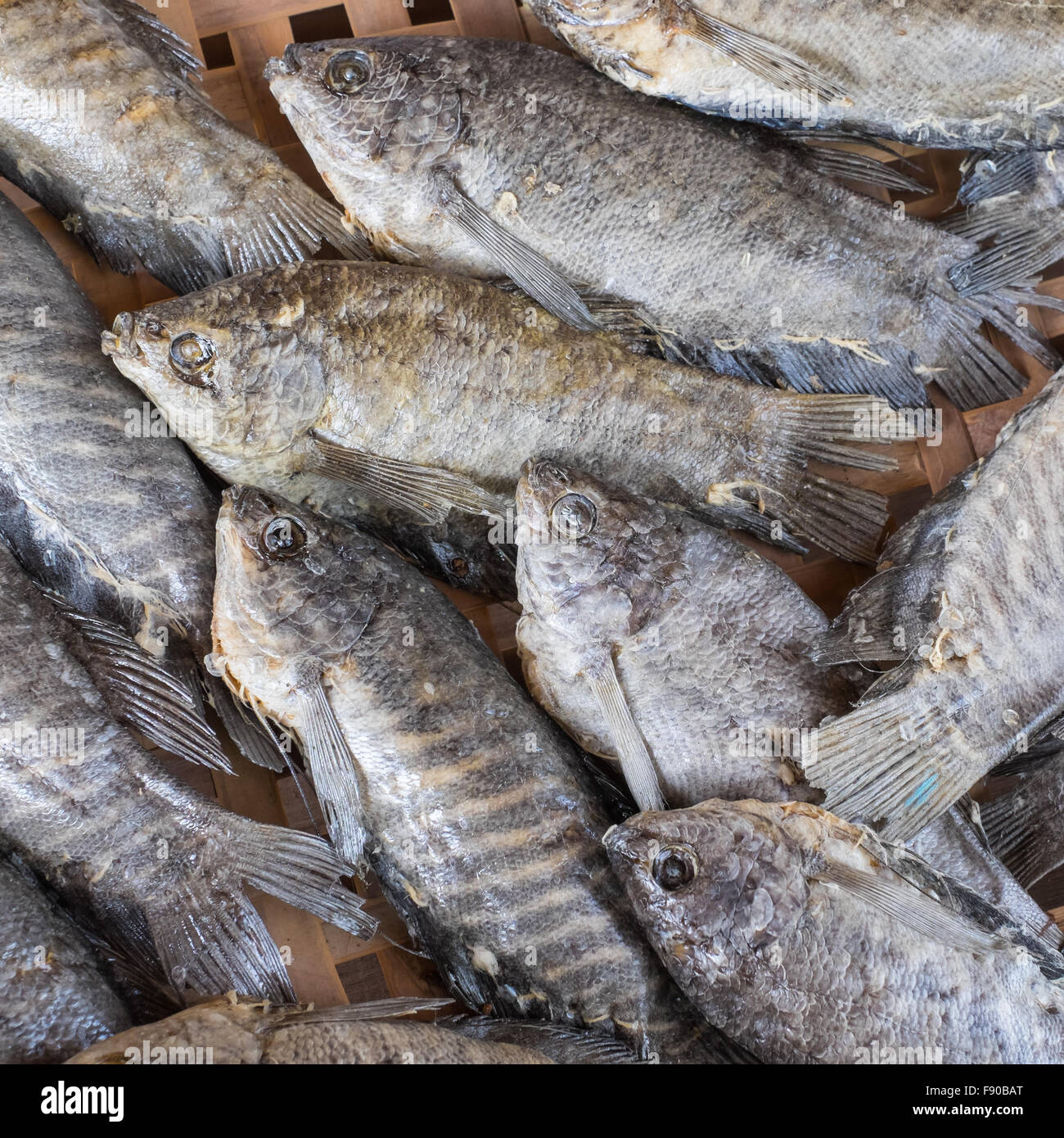 Dried Trichogaster pectoralis fish on threshing basket Stock Photo