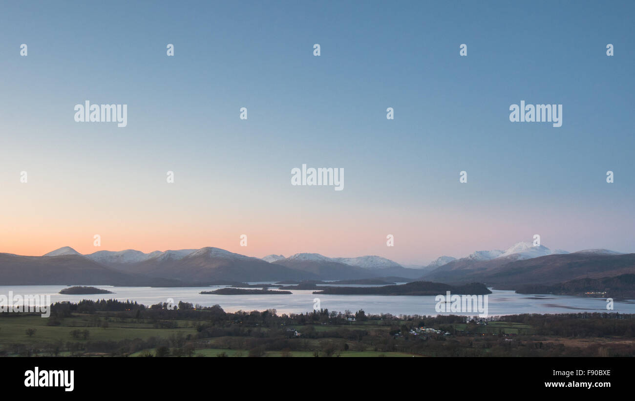 Gartocharn, Loch Lomond, Scotland, UK. 12th December, 2015. UK weather - a perfect winter evening view of Loch Lomond and the Southern Highlands, with the snow capped peak of Ben Lomond on the right and not a cloud in the sky Credit:  kayrtravel/Alamy Live News Stock Photo