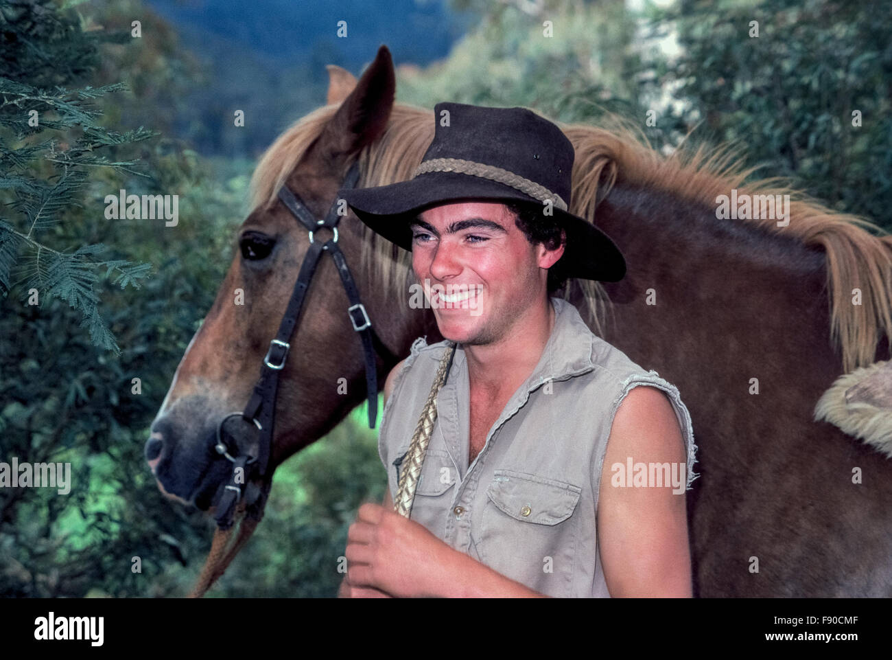 A young Aussie cowboy greets visitors with a smile in Snowy River country at Stockyard Creek near Mansfield, Victoria, Australia. Chris Stoney is also an actor who appeared in the 1988 Western adventure film, 'Return to Snowy River.' It was a sequel to the 1982 hit, 'The Man From Snowy River,' which starred Kirk Douglas and was nominated for a Golden Globe award as the Best Foreign Film. Model Released. Stock Photo