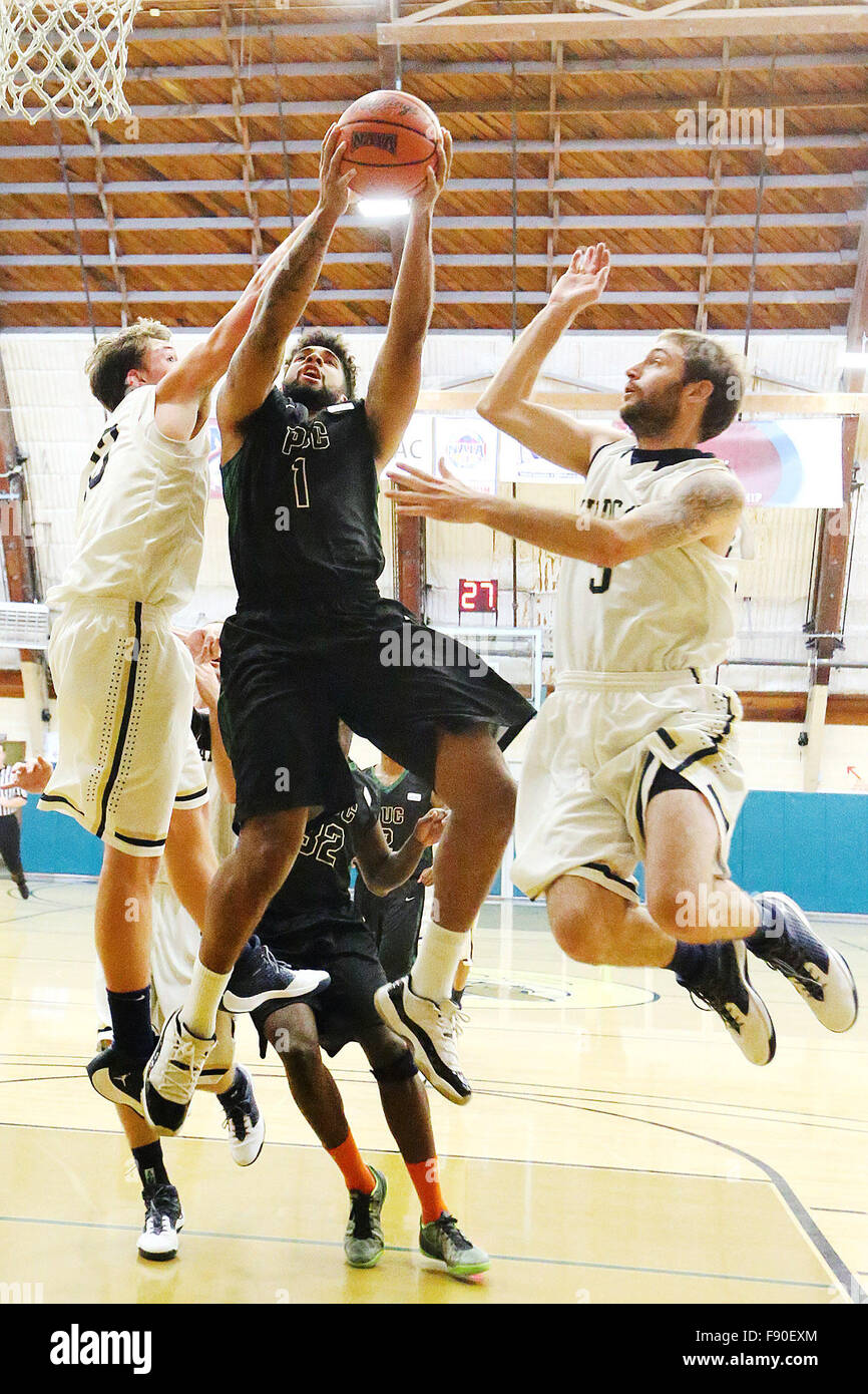 Angwin, CA, USA. 11th Dec, 2015. Pacific Union College's Devon Marshall tries to put up a shot under heavy coverage from Aaron Stone, left, and Tony Baldocchi, right, during the Pioneers game against Johnson & Wales University at Pacific Union College in Angwin on Friday. © Napa Valley Register/ZUMA Wire/Alamy Live News Stock Photo