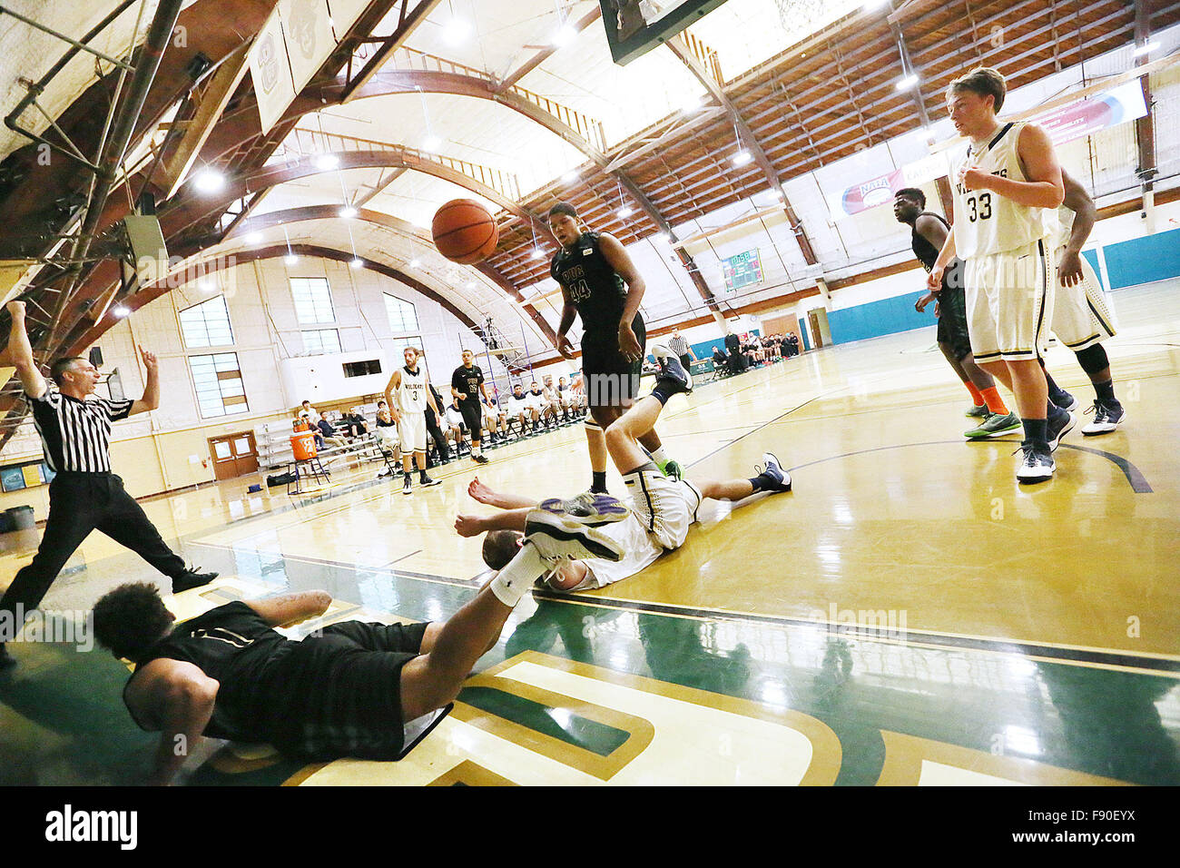 Angwin, CA, USA. 11th Dec, 2015. The referee signals a foul after Pacific Union College's Devon Marshall, bottom left, and Johnson & Wales' Andrew Bonner, center, went down during the Pioneers game against Johnson & Wales University at Pacific Union College in Angwin on Friday. © Napa Valley Register/ZUMA Wire/Alamy Live News Stock Photo
