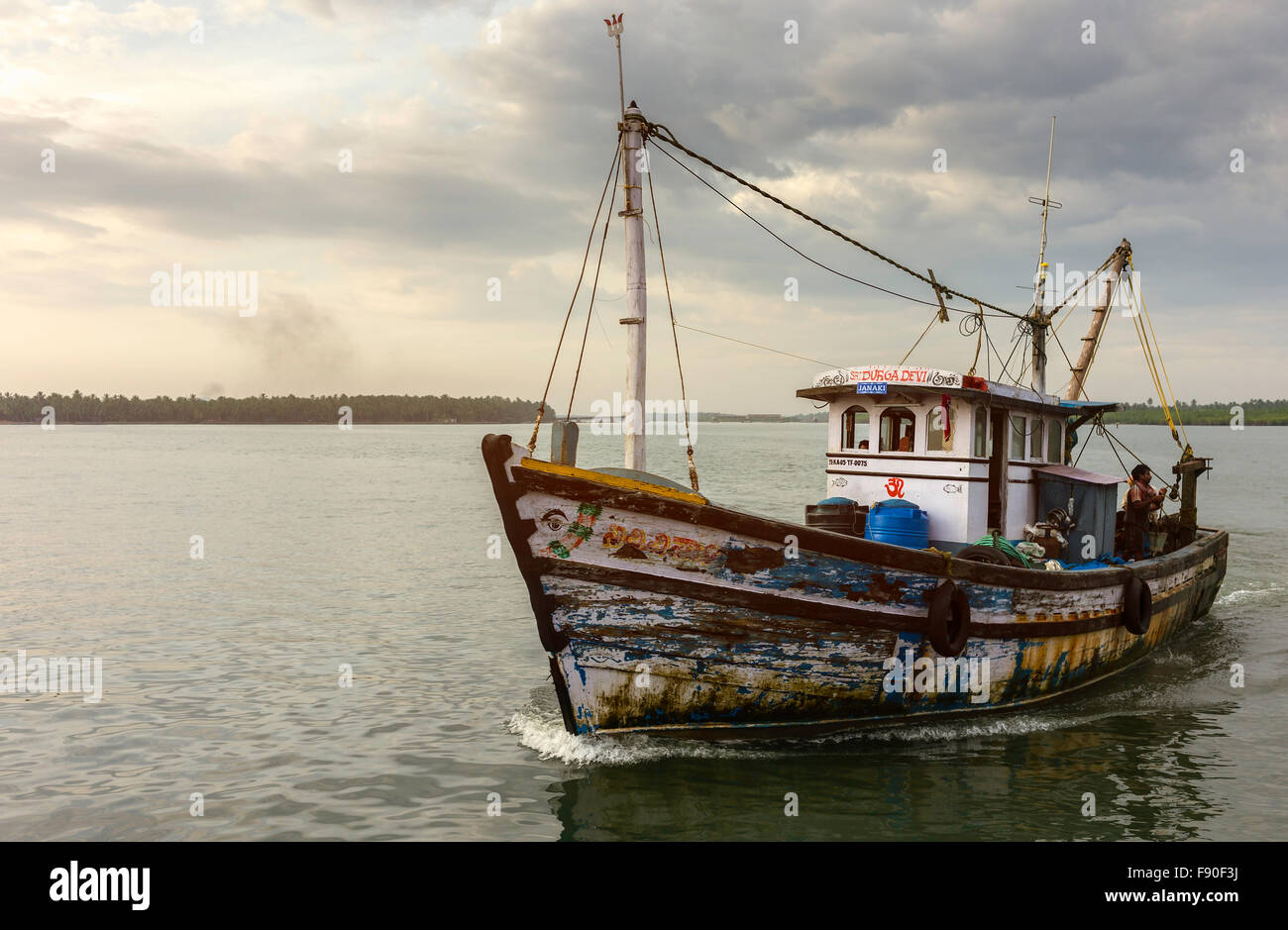 Trawler returns at dusk from deep sea fishing trip in Arabian Sea and anchor at Valapattam harbour, Kerala, India. Stock Photo