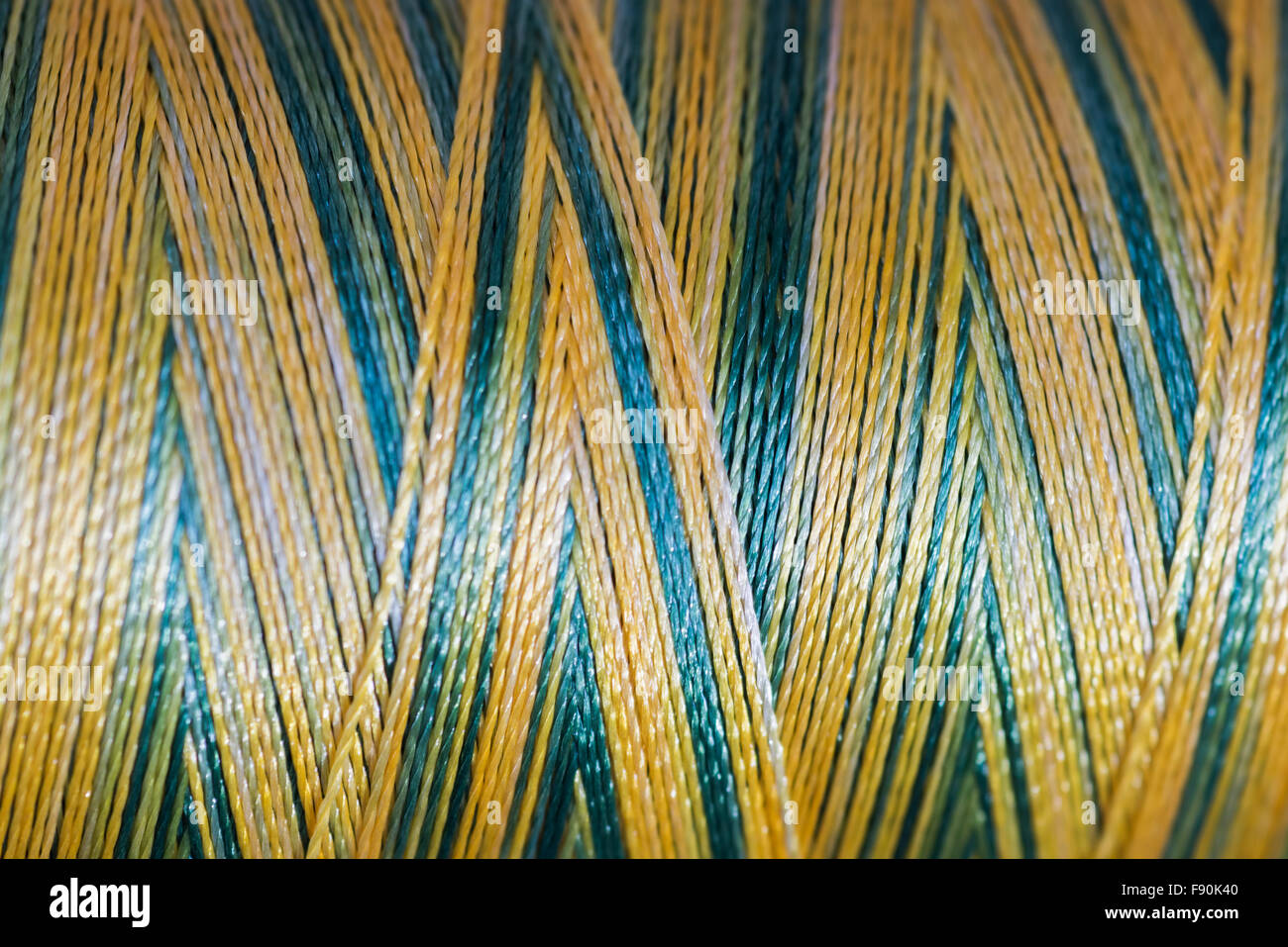 Blue and gold sewing thread up close for texture or background Stock