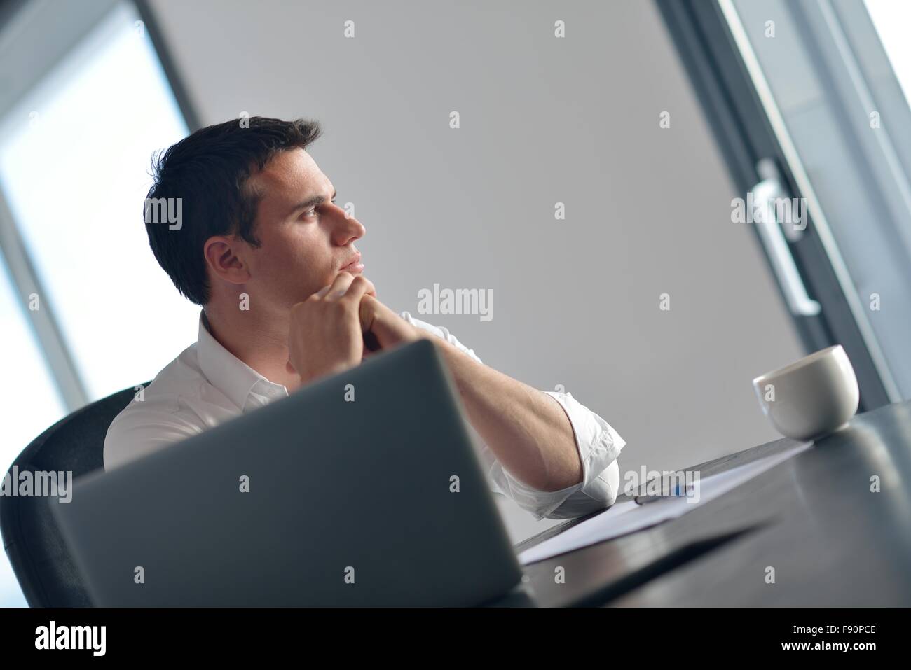 portrait of young happy business man working on laptop computer at home ...