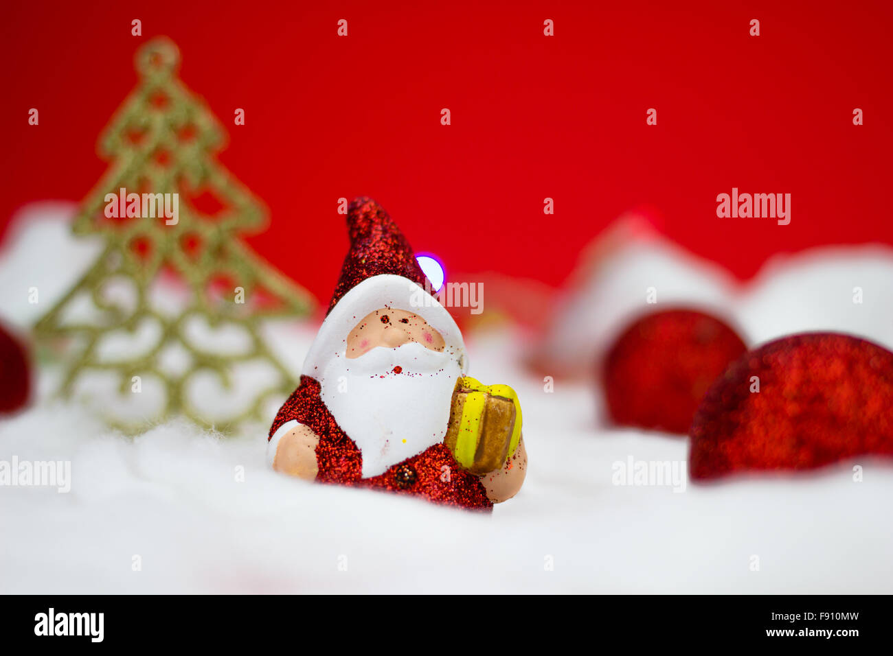 Santa Claus figurine with gift on red background Stock Photo