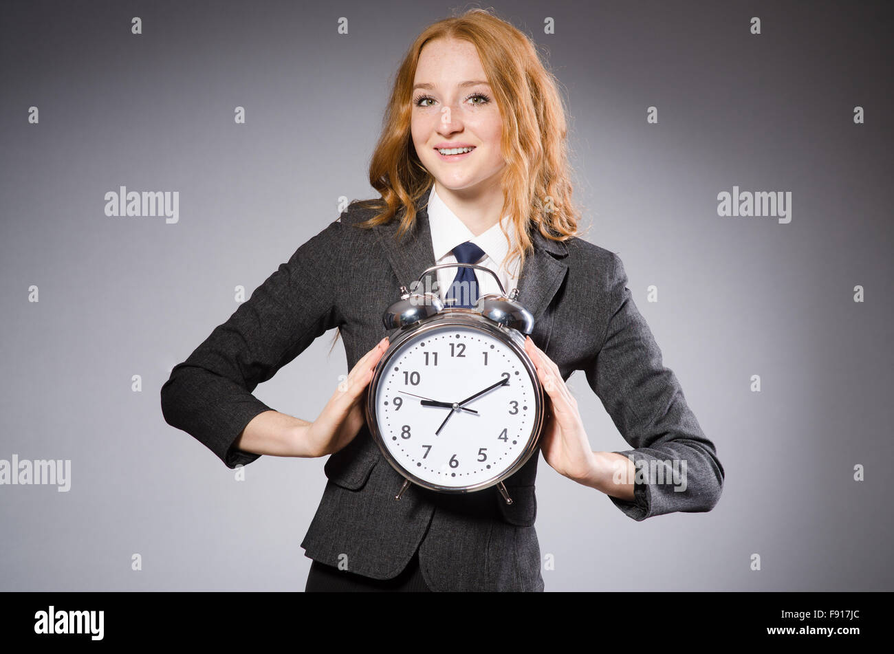 Businesswoman with clock being late for her deliverables Stock Photo