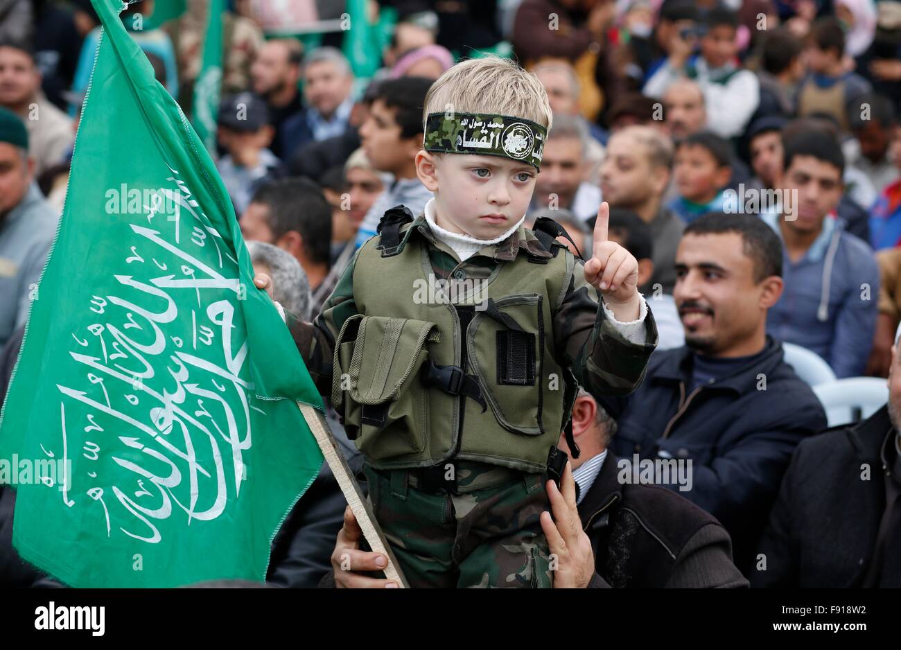 Gaza, Palestine. 11th Dec, 2015. A child hold Hamas flag during the Hamas anniversary celebration. Thousands of Hamas supporters in the city of Khan Younis gather to celebrate the 28th anniversary of its existence. © Ramadan El-Agha/Pacific Press/Alamy Live News Stock Photo
