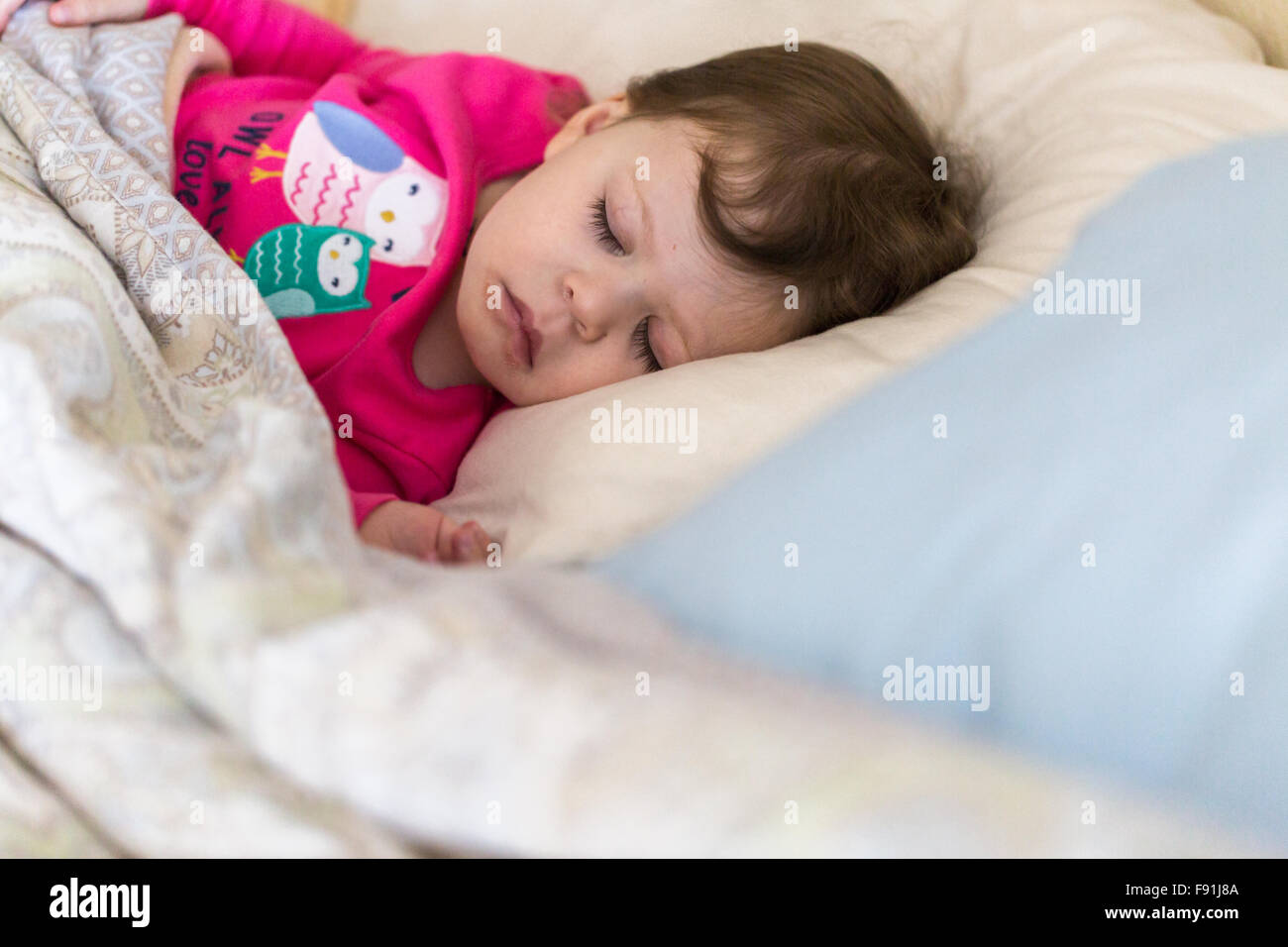 Baby girl sleeping in her parents bed Stock Photo Alamy