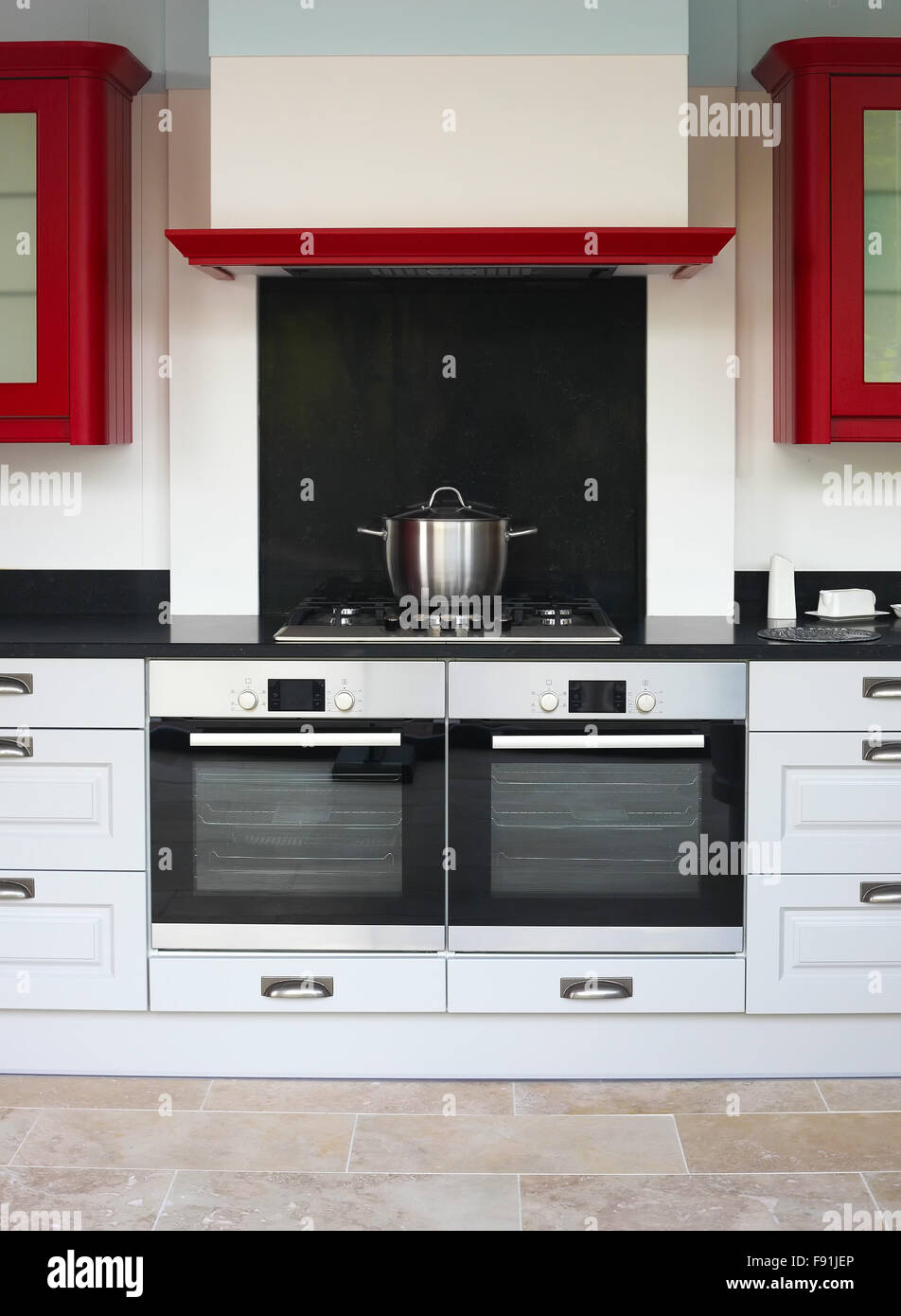 Modern black and white kitchen interior with red cupboards Stock Photo