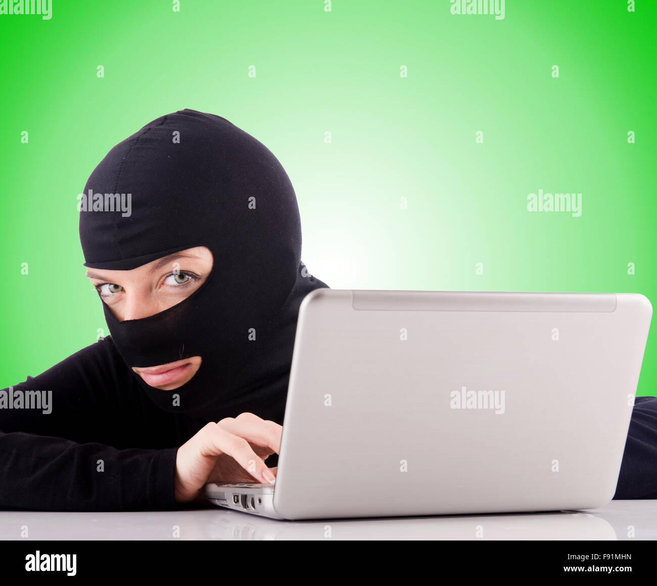 Hacker with computer wearing balaclava Stock Photo - Alamy