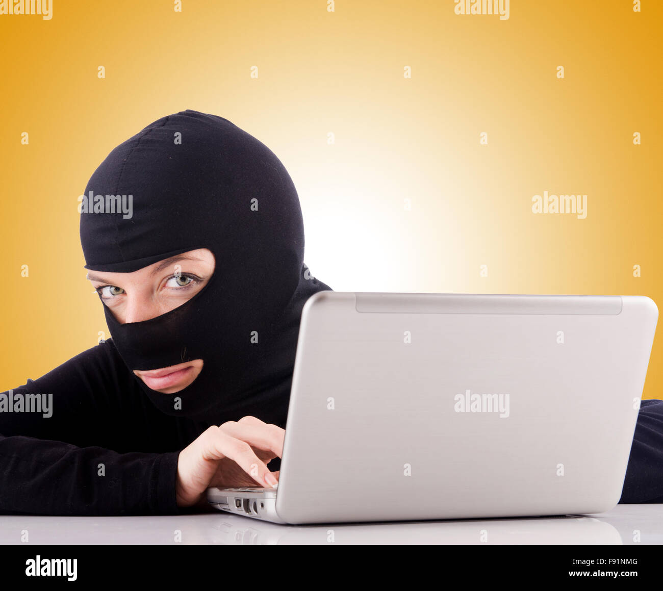 Hacker with computer wearing balaclava Stock Photo - Alamy