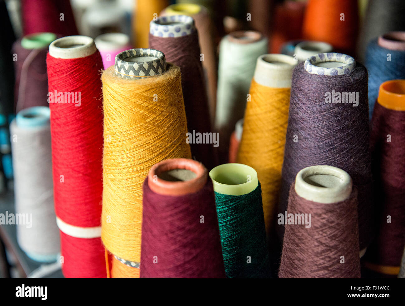 Colorful assortment of vivid colors of cotton spools on cardboard cones for use in the knitwear and garment industry viewed high Stock Photo