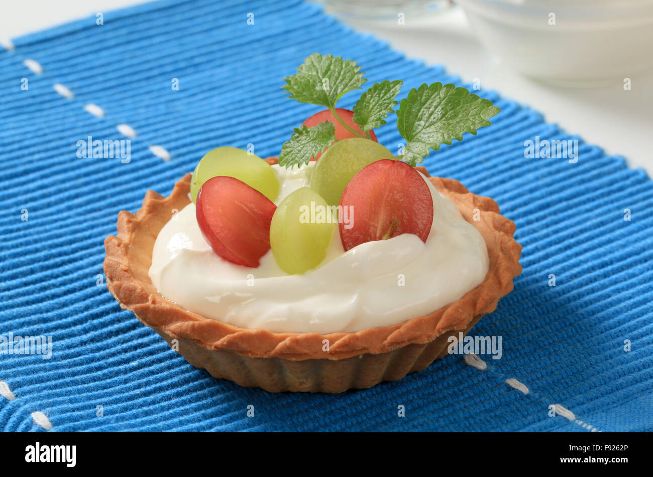 Small cream tart topped with fresh grapes Stock Photo