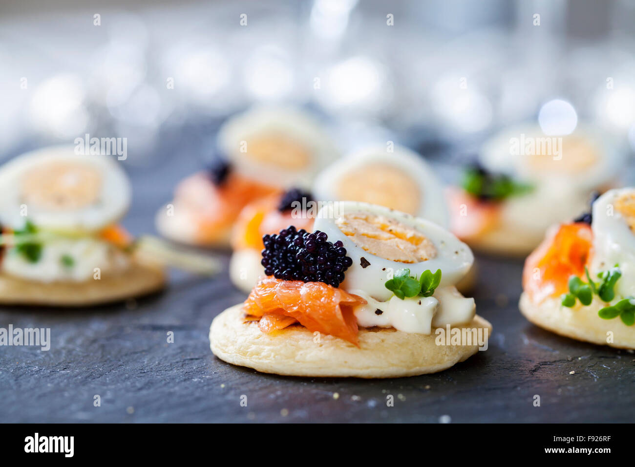 Party food, blinis with salmon, quail egg and caviar Stock Photo