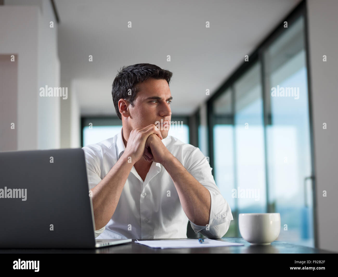 portrait of young happy business man working on laptop computer at home ...