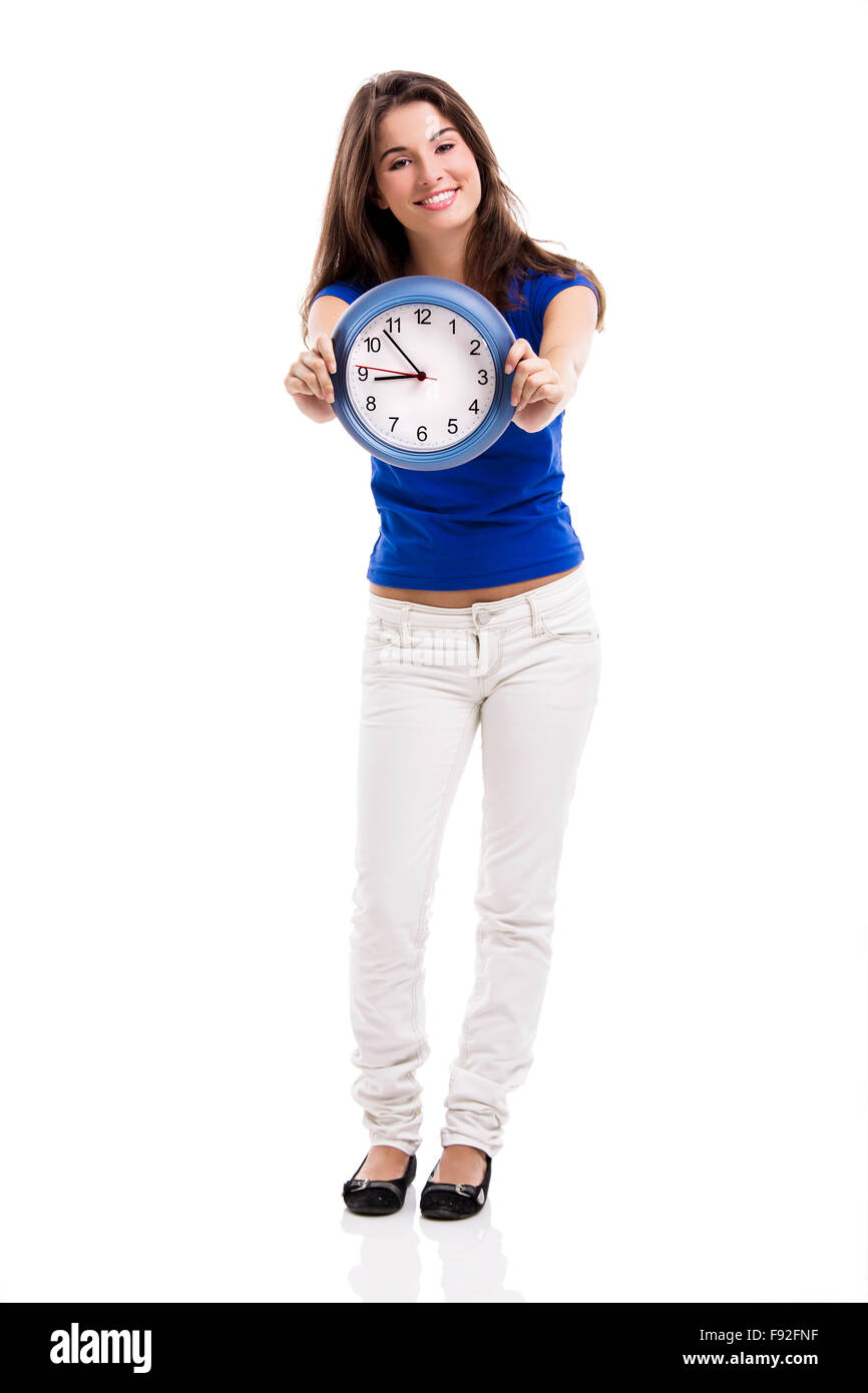 Causal young woman holding a clock, isolated over a white background Stock Photo