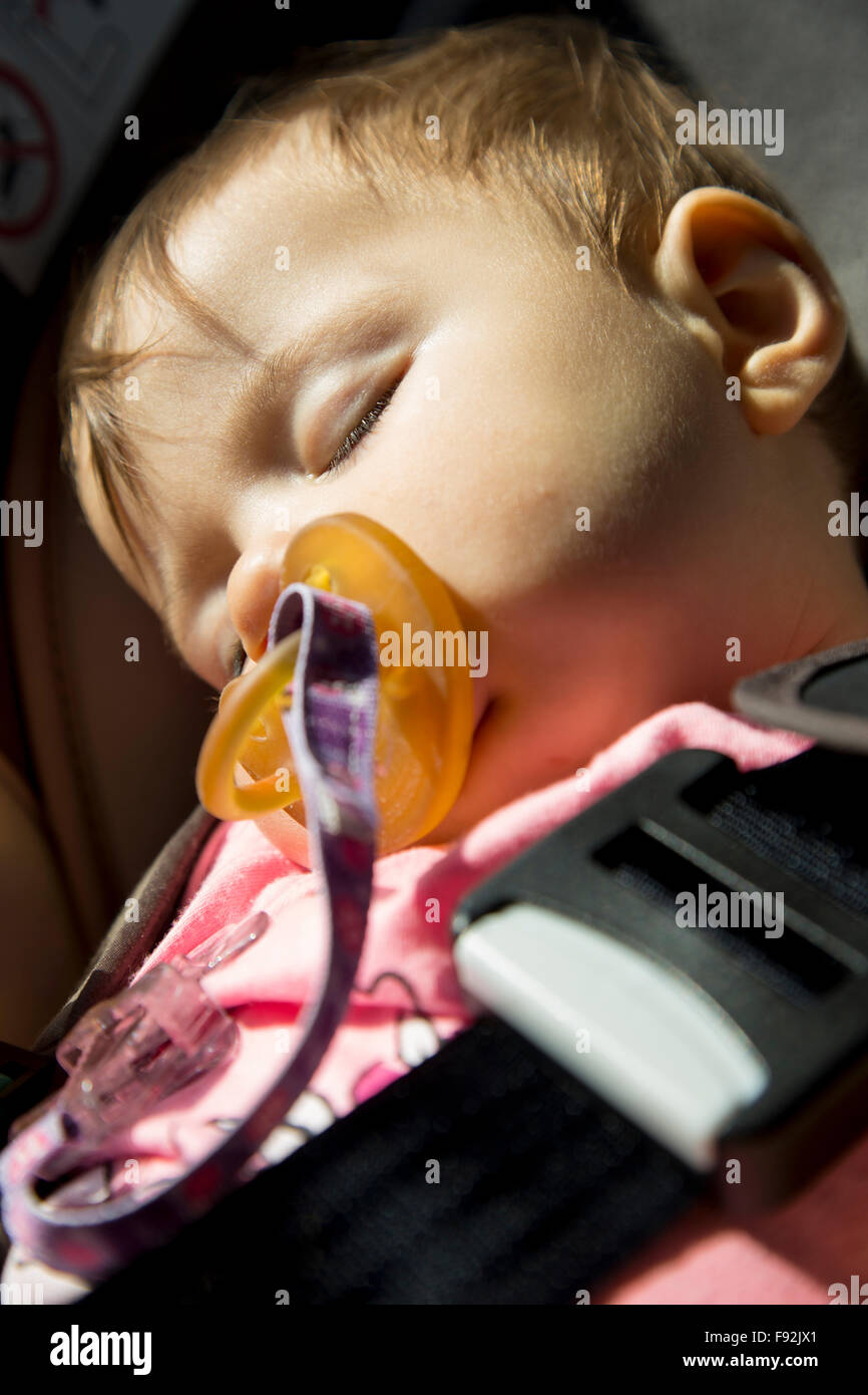 9 months old baby girl sleeping in the child car seat Stock Photo